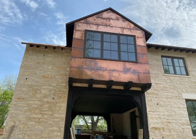 Copper metal panel facade on a stone building for Roof Repair in Granbury